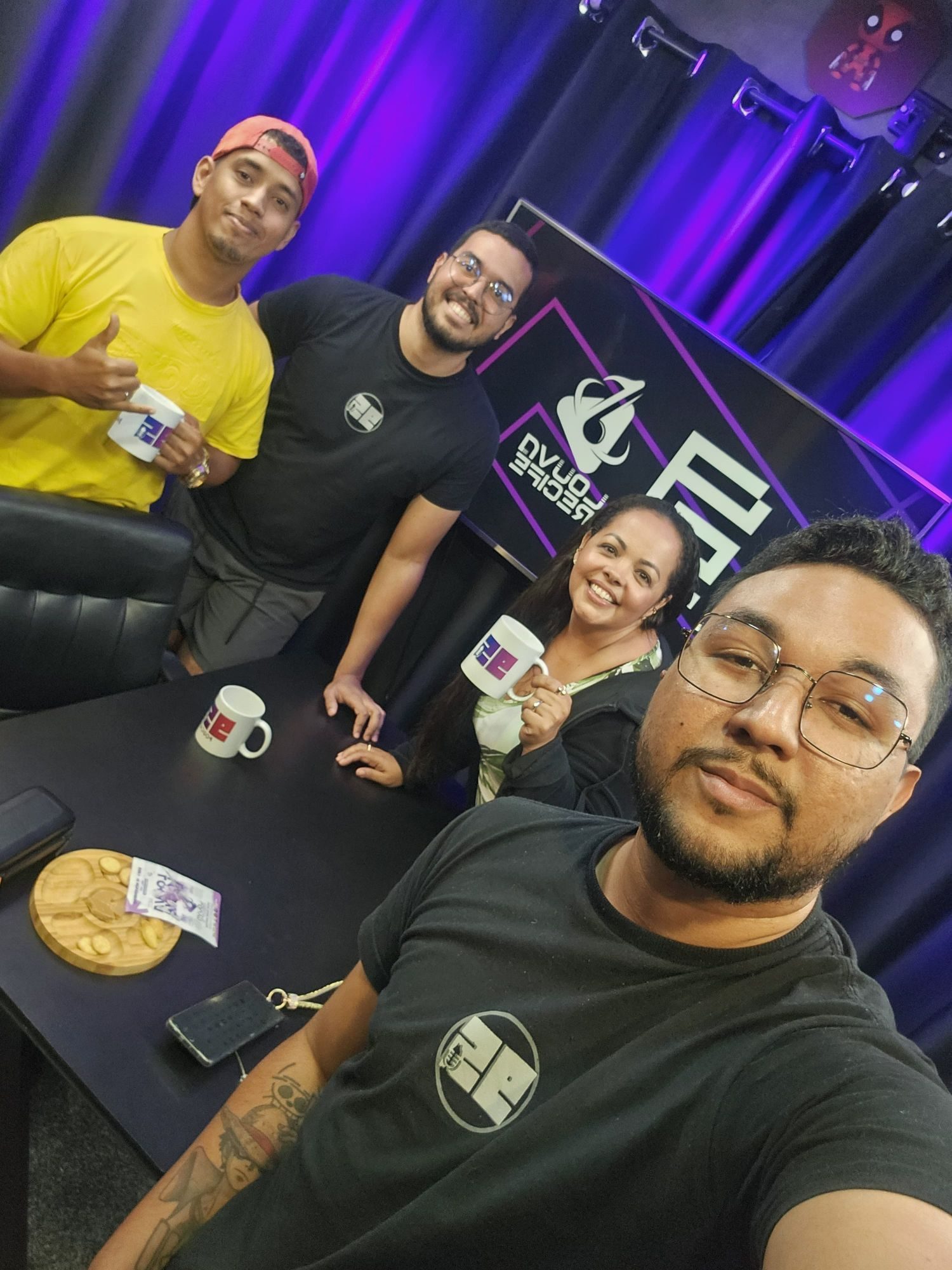 Equipe e convidados com canecas da 95 no estúdio, telão com Louva Recife